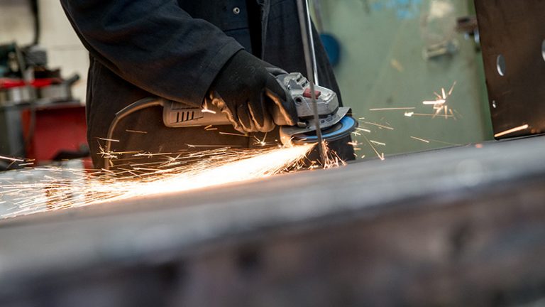 Dustcheck employee grinding metal component